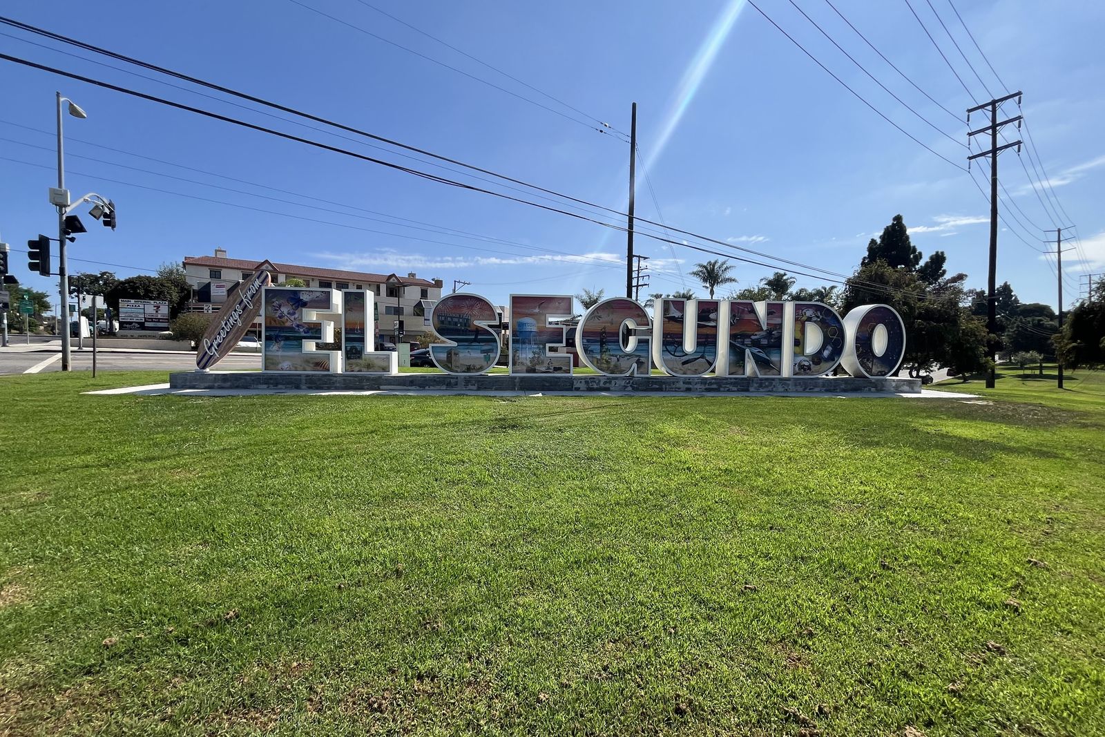 The El Segundo monument sign in freestanding letters on a grass verge beside the road.